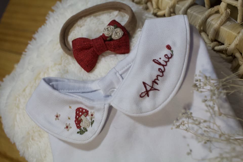 Golinhas brancas com o nome Amelie em vermelho e um cogumelo bordado