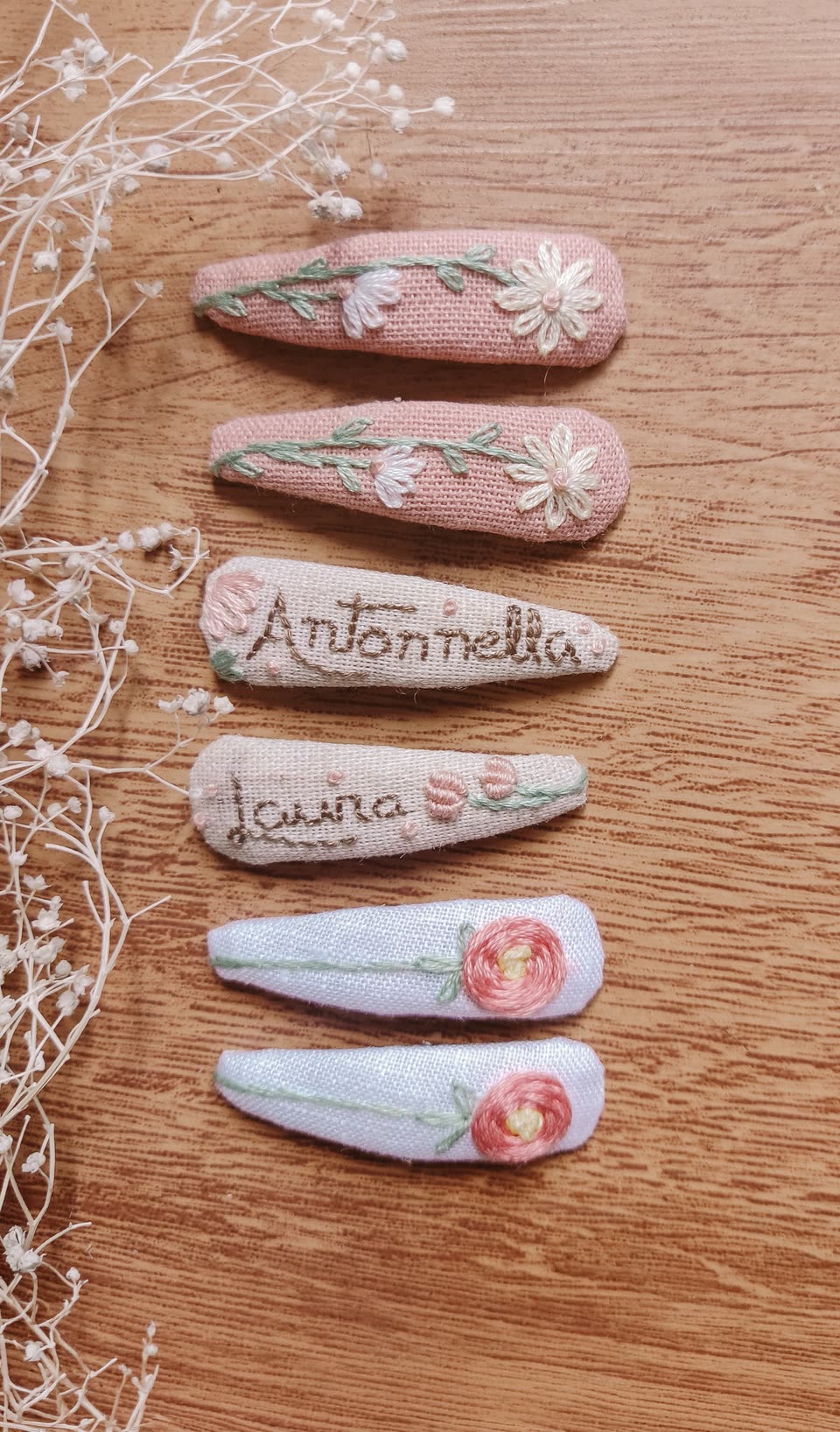 Presilhas bordadas com flores e nomes