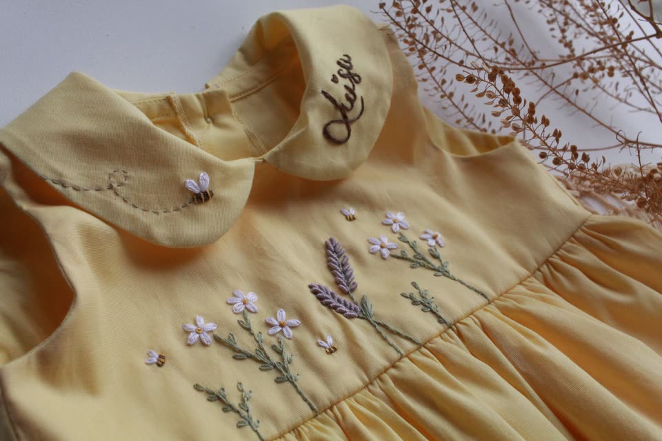 Vestido amarelo com golinha bordada com o nome Luíza e flores de lavanda