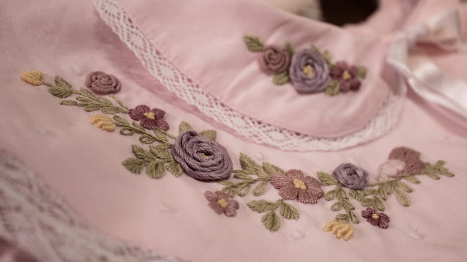 Detalhe de gola rosa com rosas em relevo bordadas